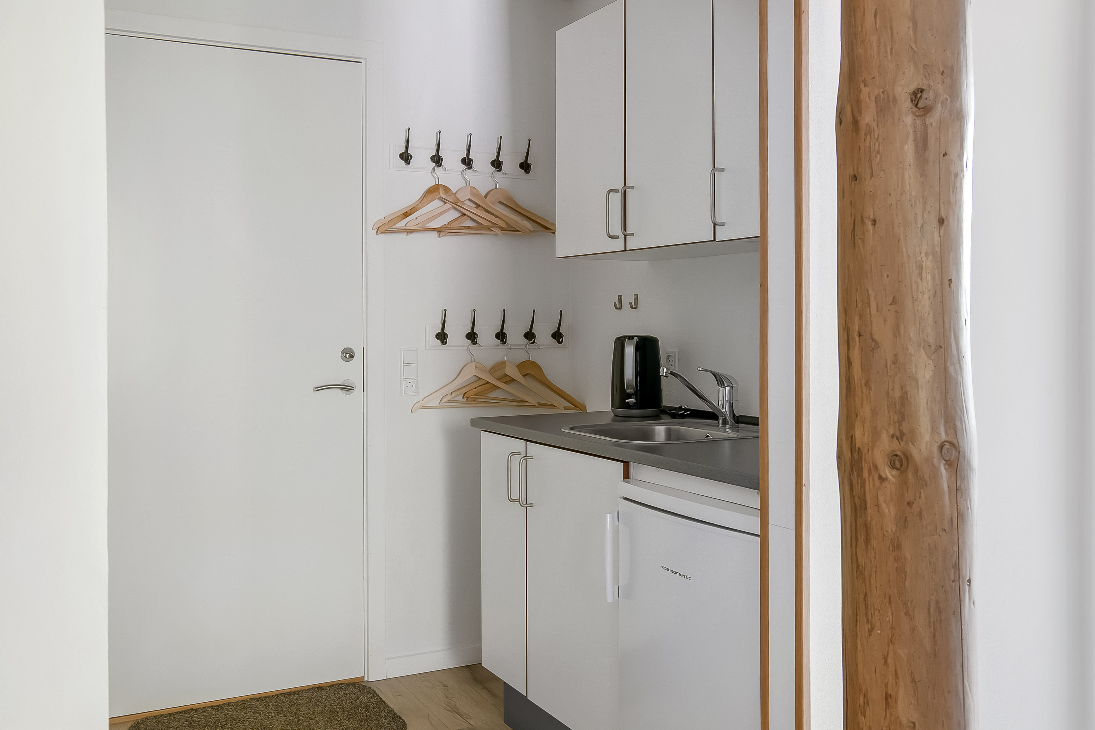 Ferielejlighed, tekøkken med lille køleskab, el-kedel og køkkenskabe. IKEA knagerække med bøjler 