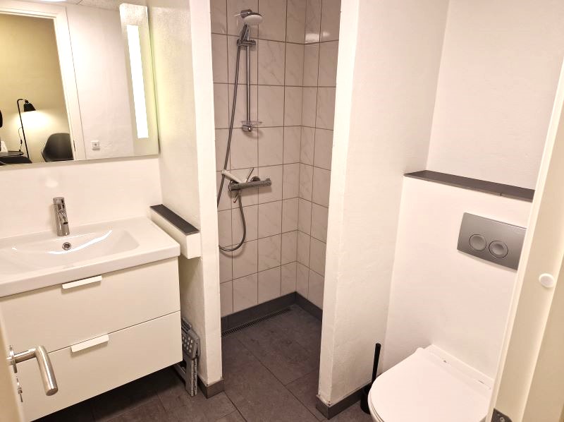 Dobbeltværelse, badeværelse med bruseniche, skabe, spejl med lys og toilet 